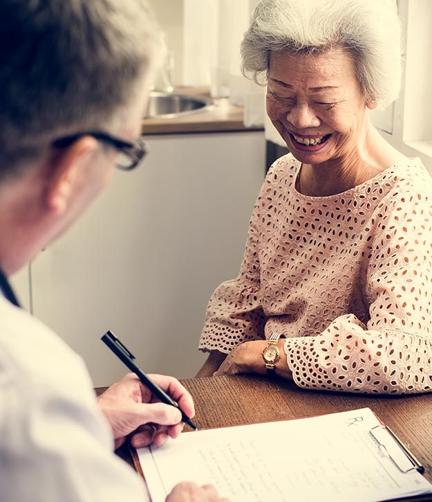 masspace-eligibililty photo of an elderly woman sitting with her doctor and smiling